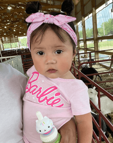 Little girl is wearing a baby headband for little girls from By Bella Boutique. Little girl is wearing a baby headband for little girls from By Bella Boutique.