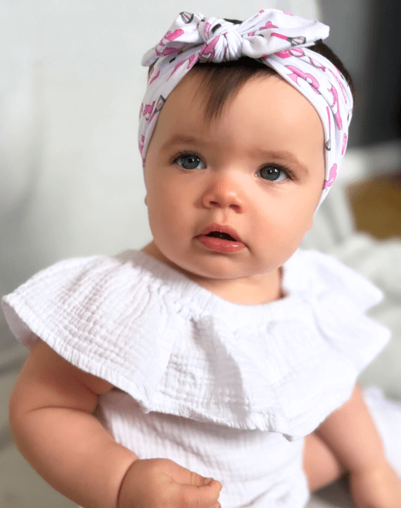 Little girl is wearing a soft baby head wrap for little girls from By Bella Boutique. Little girl is wearing a soft baby head wrap for little girls from By Bella Boutique.