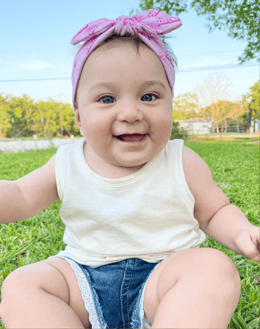 Little girl is wearing a comfortable baby headband for little girls from By Bella Boutique. Little girl is wearing a comfortable baby headband for little girls from By Bella Boutique.