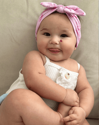 Baby girl is wearing a soft baby head wrap for little girls from By Bella Boutique. Baby girl is wearing a soft baby head wrap for little girls from By Bella Boutique.