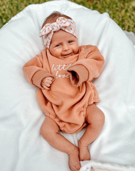 Baby girl is wearing a comfortable baby headband for little girls from By Bella Boutique. Baby girl is wearing a comfortable baby headband for little girls from By Bella Boutique.