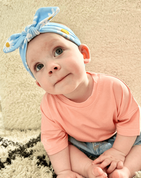 Little girl is wearing a comfortable baby head wrap for little girls from By Bella Boutique. Little girl is wearing a comfortable baby head wrap for little girls from By Bella Boutique.