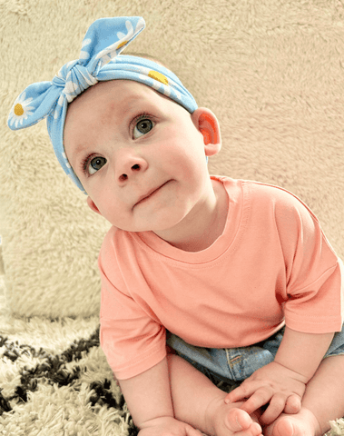 Little girl is wearing a comfortable baby head wrap for little girls from By Bella Boutique. Little girl is wearing a comfortable baby head wrap for little girls from By Bella Boutique.