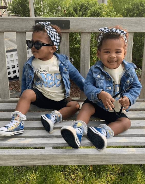 Little girls are wearing a baby head wrap featuring a checkerboard pattern for little girls from By Bella Boutique. Little girls are wearing a baby head wrap featuring a checkerboard pattern for little girls from By Bella Boutique.