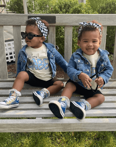 Little girls are wearing a baby head wrap featuring a checkerboard pattern for little girls from By Bella Boutique. Little girls are wearing a baby head wrap featuring a checkerboard pattern for little girls from By Bella Boutique.