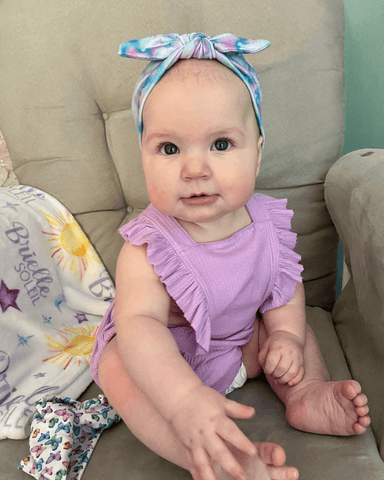Little girl is wearing a baby girl headband for little girls from By Bella Boutique. Little girl is wearing a baby girl headband for little girls from By Bella Boutique.