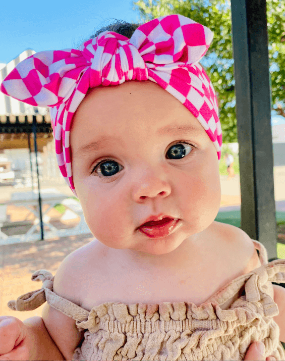 Little girl is wearing a baby headband for little girls from By Bella Boutique. Little girl is wearing a baby headband for little girls from By Bella Boutique.