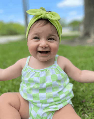 Baby girl is wearing a lime green knot headband for little girls from By Bella Boutique. Baby girl is wearing a lime green knot headband for little girls from By Bella Boutique.