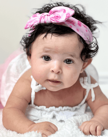 Baby girl is wearing a comfortable baby headband for little girls from By Bella Boutique. Baby girl is wearing a comfortable baby headband for little girls from By Bella Boutique.