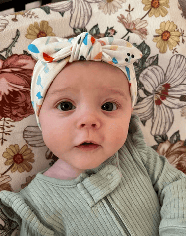 Baby girl is wearing a knotted headband featuring a boho mushroom pattern for little girls from By Bella Boutique. Baby girl is wearing a knotted headband featuring a boho mushroom pattern for little girls from By Bella Boutique.