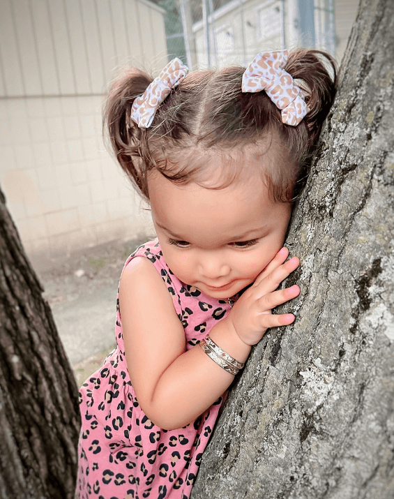Little girl is wearing a set of handmade bow clips for toddler girls from By Bella Boutique. Little girl is wearing a set of handmade bow clips for toddler girls from By Bella Boutique.