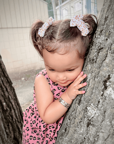 Little girl is wearing a set of handmade bow clips for toddler girls from By Bella Boutique. Little girl is wearing a set of handmade bow clips for toddler girls from By Bella Boutique.