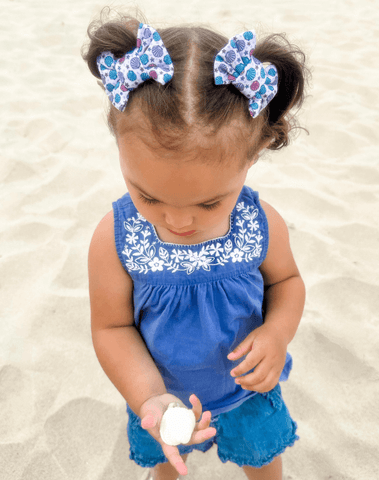 Little girl is wearing a pair of handmade clip bows for toddler girls from By Bella Boutique. Little girl is wearing a pair of handmade clip bows for toddler girls from By Bella Boutique.