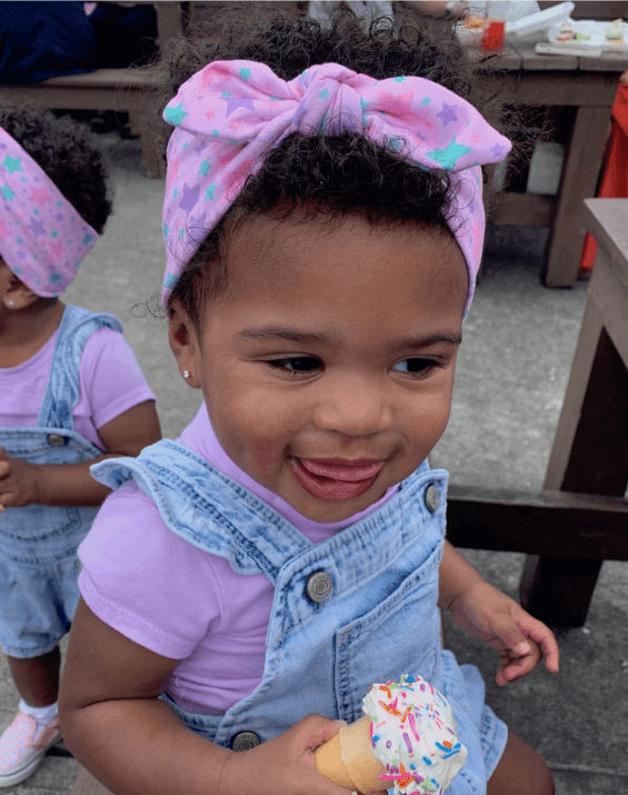 Toddler girl is wearing a knotted headband for little girls from By Bella Boutique. Toddler girl is wearing a knotted headband for little girls from By Bella Boutique.