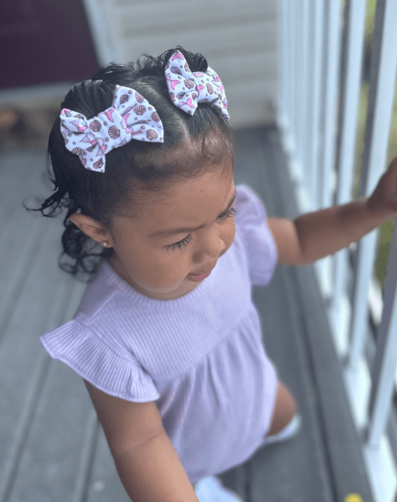 Little girl is wearing a pair of handmade clip bows for little girls from By Bella Boutique. Little girl is wearing a pair of handmade clip bows for little girls from By Bella Boutique.
