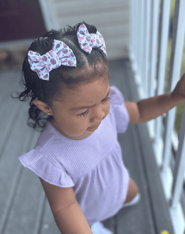 Little girl is wearing a pair of handmade clip bows for little girls from By Bella Boutique. Little girl is wearing a pair of handmade clip bows for little girls from By Bella Boutique.