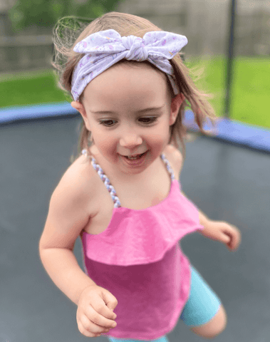 Little girl is wearing a baby headband for little girls from By Bella Boutique. Little girl is wearing a baby headband for little girls from By Bella Boutique.