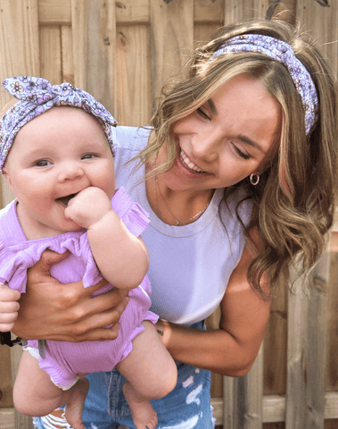 Mom and daughter are wearing matching mommy and me head wraps from By Bella Boutique. Mom and daughter are wearing matching mommy and me head wraps from By Bella Boutique.