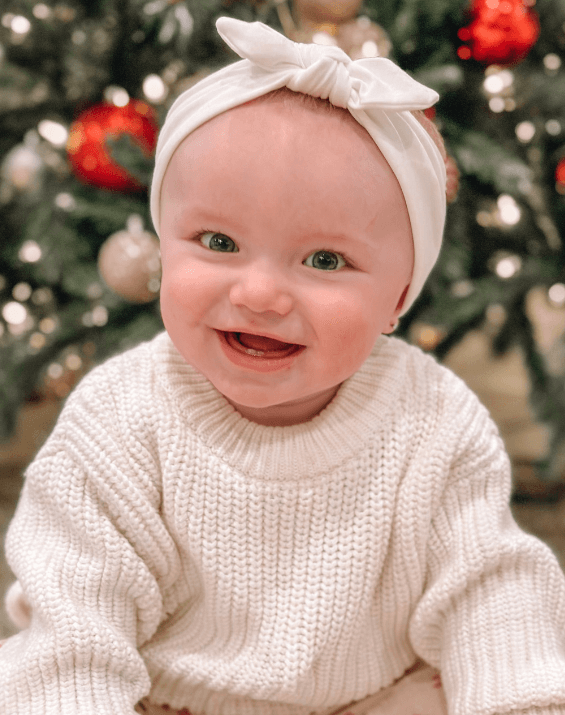 Little girl is wearing a comfortable baby head wrap for little girls from By Bella Boutique. Little girl is wearing a comfortable baby head wrap for little girls from By Bella Boutique.