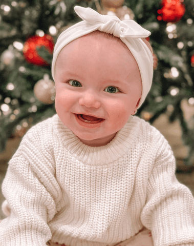 Little girl is wearing a comfortable baby head wrap for little girls from By Bella Boutique. Little girl is wearing a comfortable baby head wrap for little girls from By Bella Boutique.