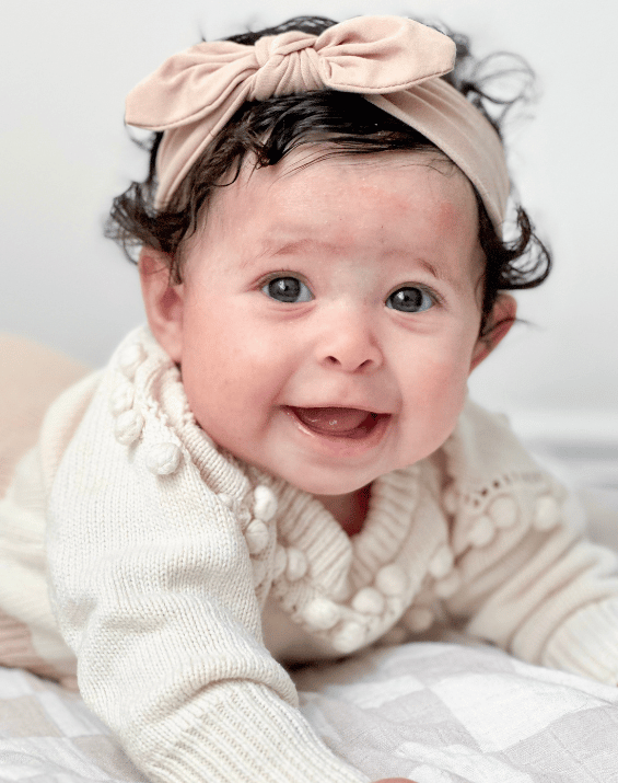 Baby girl is wearing a comfortable baby head wrap for little girls from By Bella Boutique. Baby girl is wearing a comfortable baby head wrap for little girls from By Bella Boutique.