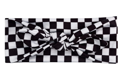 A knotted headband for little girls featuring a white checkerboard pattern from By Bella Boutique.  A knotted headband for little girls featuring a white checkerboard pattern from By Bella Boutique.