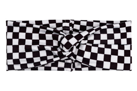 A mommy and me head wrap featuring a white checkerboard pattern from By Bella Boutique. A mommy and me head wrap featuring a white checkerboard pattern from By Bella Boutique.