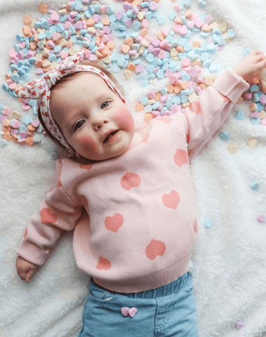 Little girl is wearing a comfortable baby head wrap featuring a heart pattern for little girls from By Bella Boutique. Little girl is wearing a comfortable baby head wrap featuring a heart pattern for little girls from By Bella Boutique.