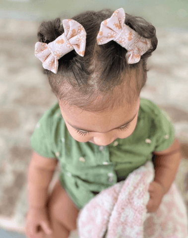 Little girl is wearing a set of handmade clips bows for toddler girls from By Bella Boutique. Little girl is wearing a set of handmade clips bows for toddler girls from By Bella Boutique.