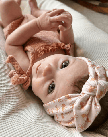 Baby girl is wearing a comfortable baby headband from By Bella Boutique. Baby girl is wearing a comfortable baby headband from By Bella Boutique.