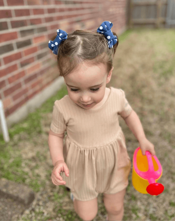 Toddler girl is wearing a set of clip bows for toddler girls from By Bella Boutique. Toddler girl is wearing a set of clip bows for toddler girls from By Bella Boutique.