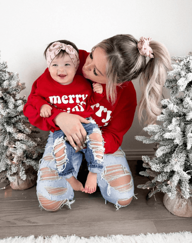 Mom and daughter are wearing matching headbands featuring a candy cane print from By Bella Boutique. Mom and daughter are wearing matching headbands featuring a candy cane print from By Bella Boutique.