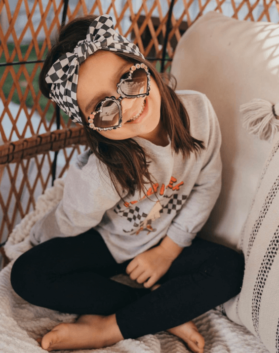 Little girl is wearing a knotted head wrap for little girls from By Bella Boutique. Little girl is wearing a knotted head wrap for little girls from By Bella Boutique.
