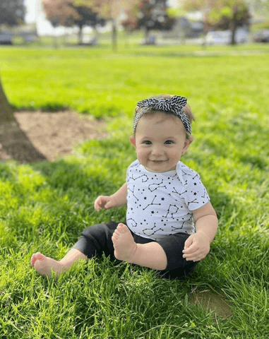 Little girl is wearing a black and white head wrap from By Bella Boutique. Little girl is wearing a black and white head wrap from By Bella Boutique.
