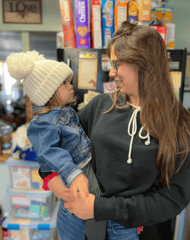 Baby girl is wearing a crochet double pom beanie from By Bella Boutique. Baby girl is wearing a crochet double pom beanie from By Bella Boutique.