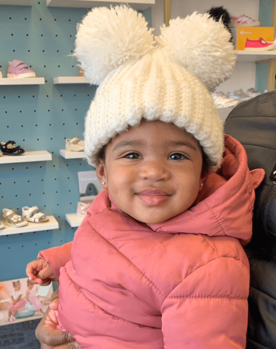 Baby girl is wearing a handmade double pom beanie from By Bella Boutique. Baby girl is wearing a handmade double pom beanie from By Bella Boutique.