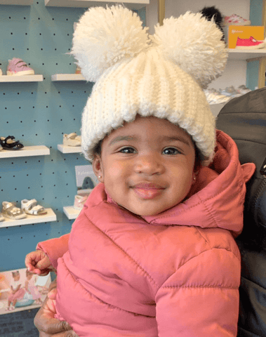 Baby girl is wearing a handmade double pom beanie from By Bella Boutique. Baby girl is wearing a handmade double pom beanie from By Bella Boutique.