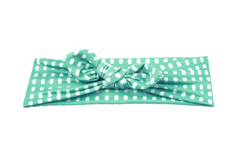 A handmade knotted headband featuring a dot pattern from By Bella Boutique. A handmade knotted headband featuring a dot pattern from By Bella Boutique.