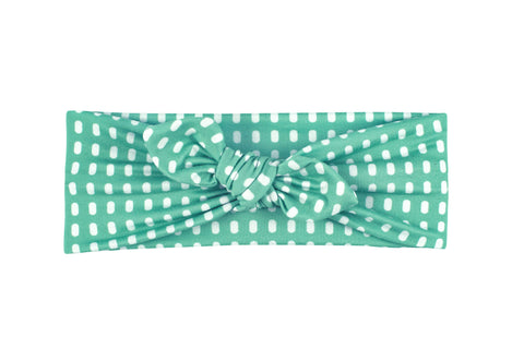 A knotted head wrap for little girls featuring a dot pattern from By Bella Boutique. A knotted head wrap for little girls featuring a dot pattern from By Bella Boutique.