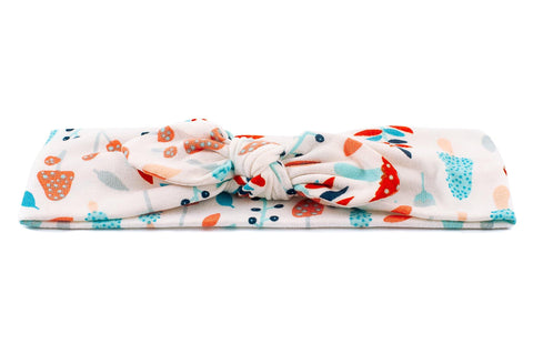 A knotted head wrap featuring a mushroom pattern from By Bella Boutique. A knotted head wrap featuring a mushroom pattern from By Bella Boutique.