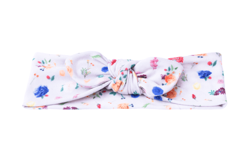 A knotted headband featuring a flower pattern for little girls from By Bella Boutique. A knotted headband featuring a flower pattern for little girls from By Bella Boutique.