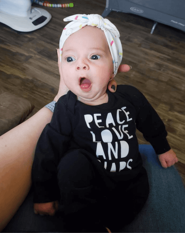 Baby girl is wearing a top knot headband featuring an ice cream pattern from By Bella Boutique. Baby girl is wearing a top knot headband featuring an ice cream pattern from By Bella Boutique.