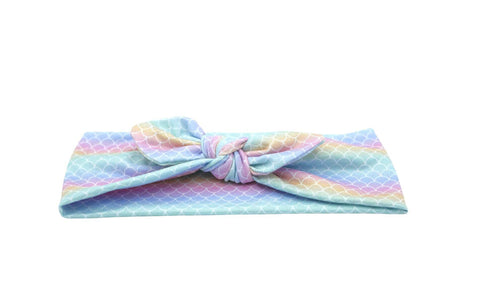 A cute knotted head wrap featuring a mermaid print for girls from By Bella Boutique. A cute knotted head wrap featuring a mermaid print for girls from By Bella Boutique.