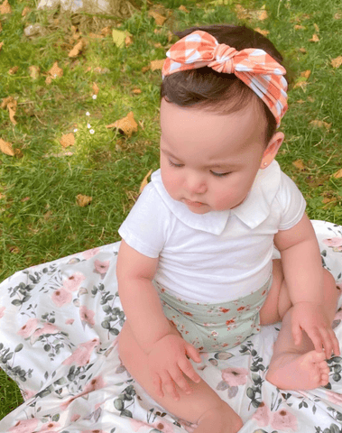 Baby girl is wearing a comfortable baby headband featuring a gingham print for little girls from By Bella Boutique. Baby girl is wearing a comfortable baby headband featuring a gingham print for little girls from By Bella Boutique.