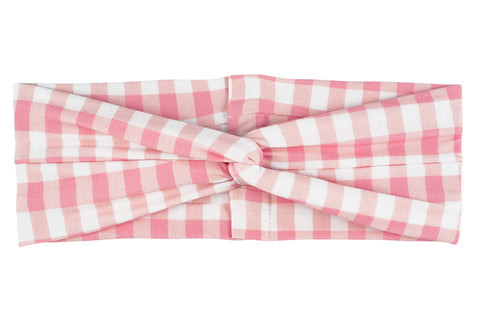 A wide twist headband featuring a pink gingham print from By Bella Boutique. A wide twist headband featuring a pink gingham print from By Bella Boutique.