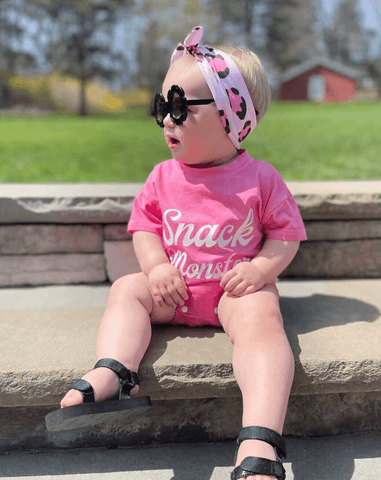 Baby girl is wearing a knotted headband featuring a pink leopard pattern from By Bella Boutique. Baby girl is wearing a knotted headband featuring a pink leopard pattern from By Bella Boutique.