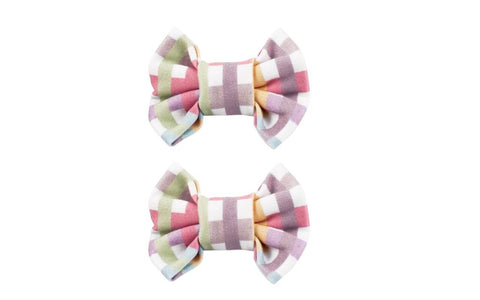 A set of two bow clips featuring a plaid pattern from By Bella Boutique.