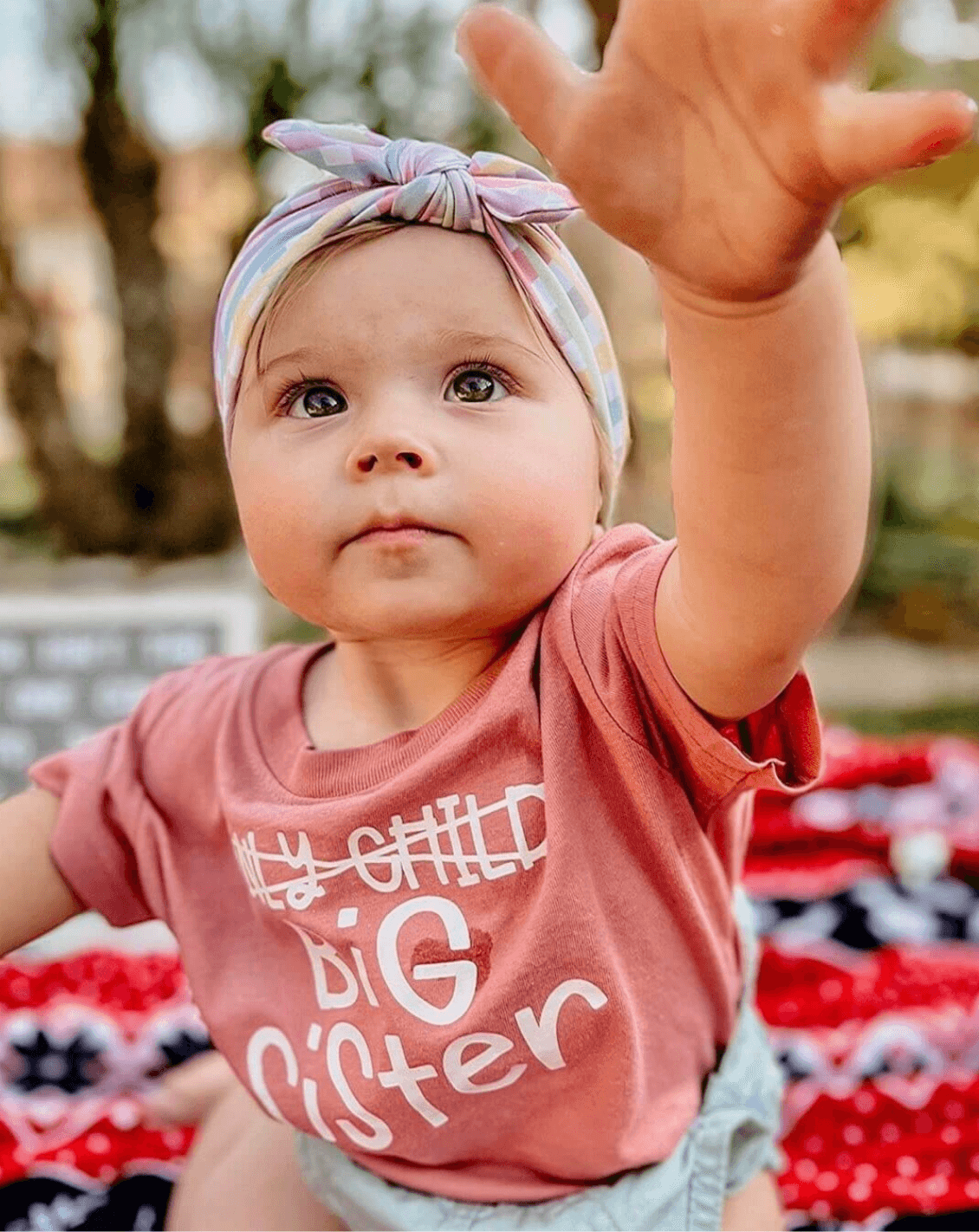 Baby girl is wearing a plaid headband for little girls from By Bella Boutique.