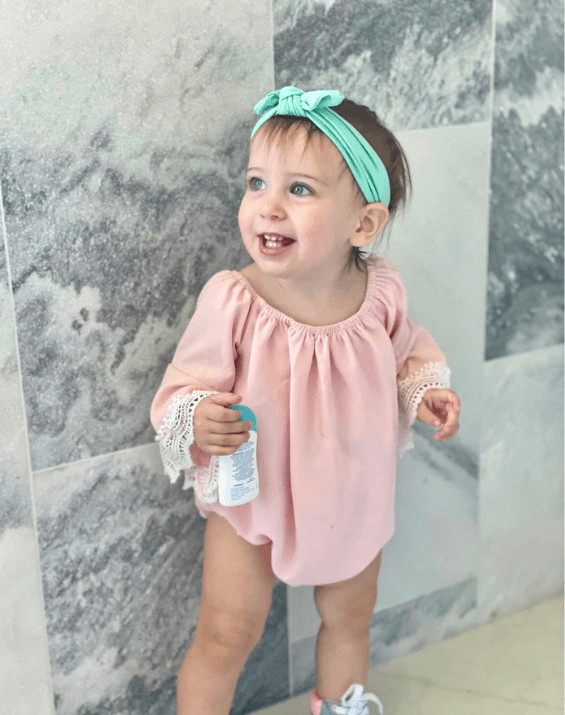 Toddler girl is wearing a green top knot headband for little girls from By Bella Boutique. Toddler girl is wearing a green top knot headband for little girls from By Bella Boutique.