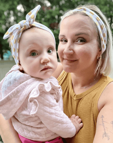 Mommy and baby girl are wearing a mommy and me head wrap from By Bella Boutique. Mommy and baby girl are wearing a mommy and me head wrap from By Bella Boutique.
